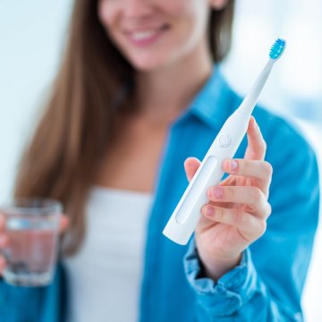 woman holding electric toothbrush